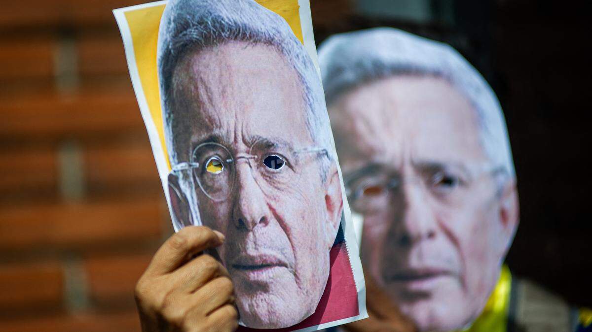 Simpatizantes del expresidente Álvaro Uribe sostienen máscaras del líder durante una protesta para denunciar el proceso judicial en su contra, el 28 de julio de 2025, en Bogotá, Colombia.