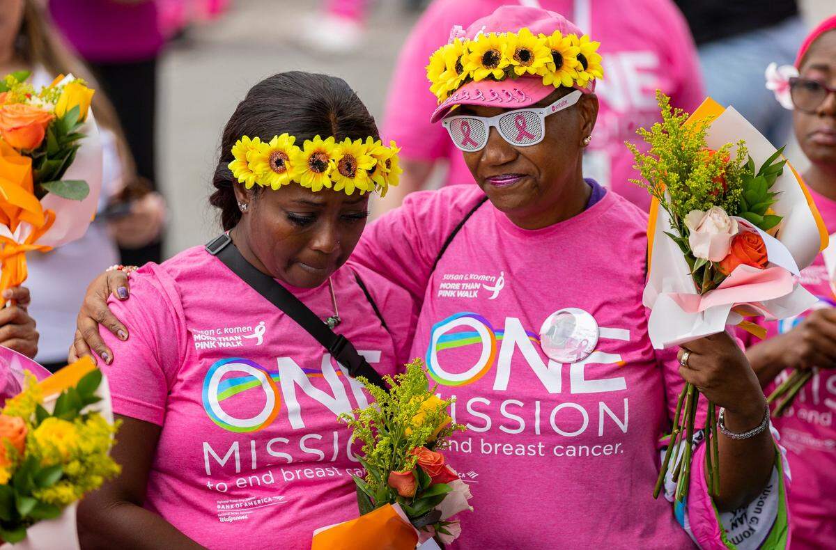 Sheila Smith, a 21-year breast cancer survivor, hugs Odessa Duncombe, a 2-year survivor, as they attend the Susan G. Komen More Than Pink Walk at Amelia Earhart Park on Saturday, Oct. 8, 2022, in Hialeah, Fla. The event raises funds for breast cancer research.