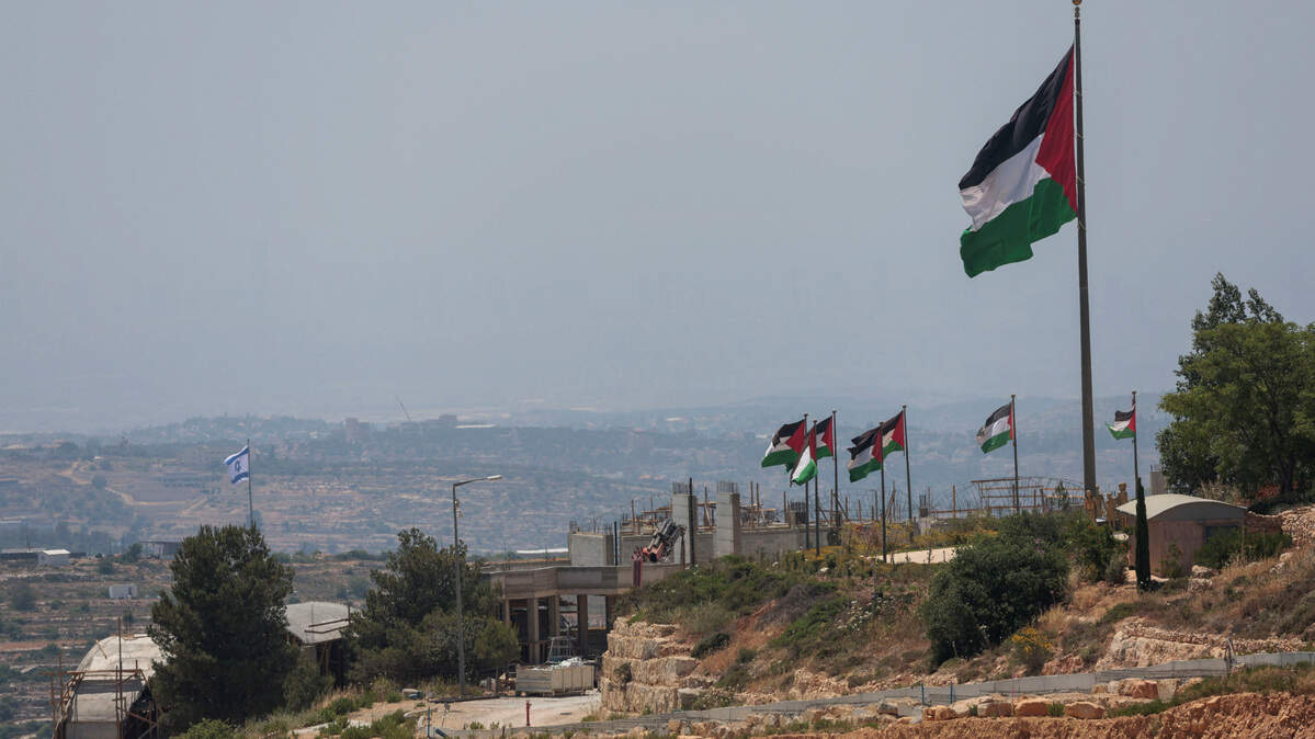 Una bandera israelí ondea en un nuevo asentamiento israelí, detrás de banderas palestinas cerca de Ramallah, en la Cisjordania ocupada por Israel, el lunes 1 de junio de 2026.