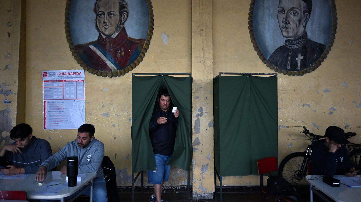 A man prepares to cast his vote during the presidential runoff election in Santiago on December 14, 2025. Chileans head to the polls for a presidential runoff between Jeannette Jara, a communist backed by a broad left coalition, and Jose Antonio Kast, a devout far-right politico promising a hard line on security and migration. (Photo by Eitan ABRAMOVICH / AFP via Getty Images)