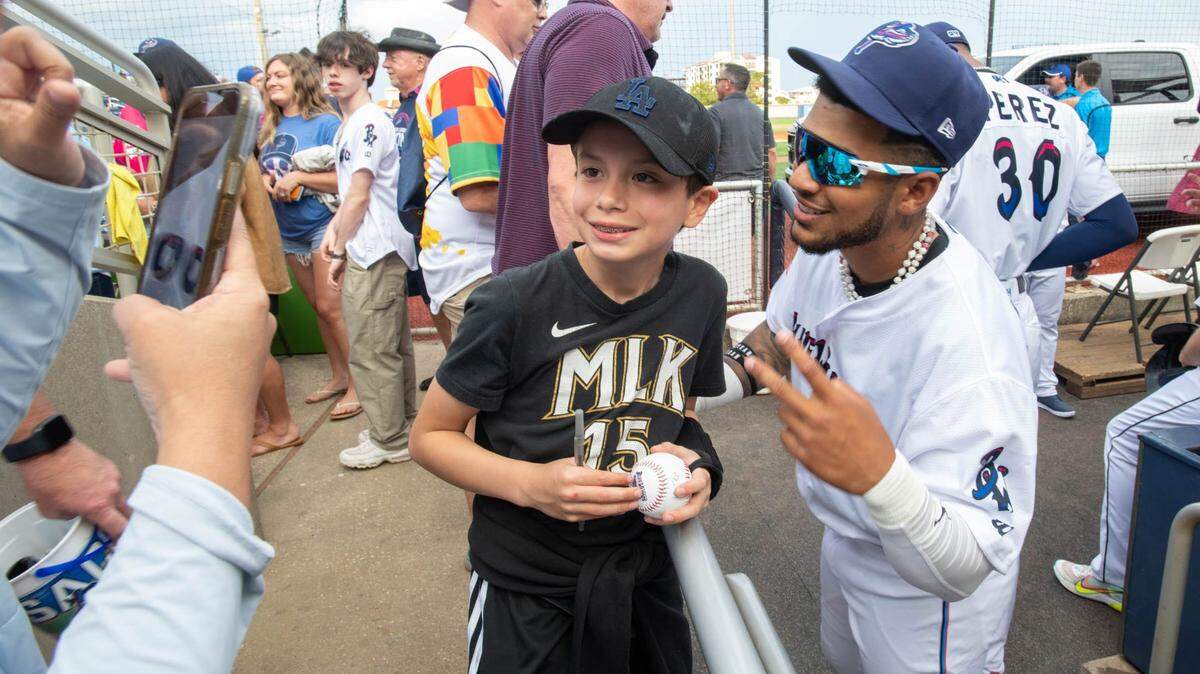 El pelotero cubano Víctor Mesa Jr. se tira una foto con un niño antes del partido de béisbol de Montgomery Biscuits contra los Pensacola Blue Wahoos, el 7 de abril de 2023.