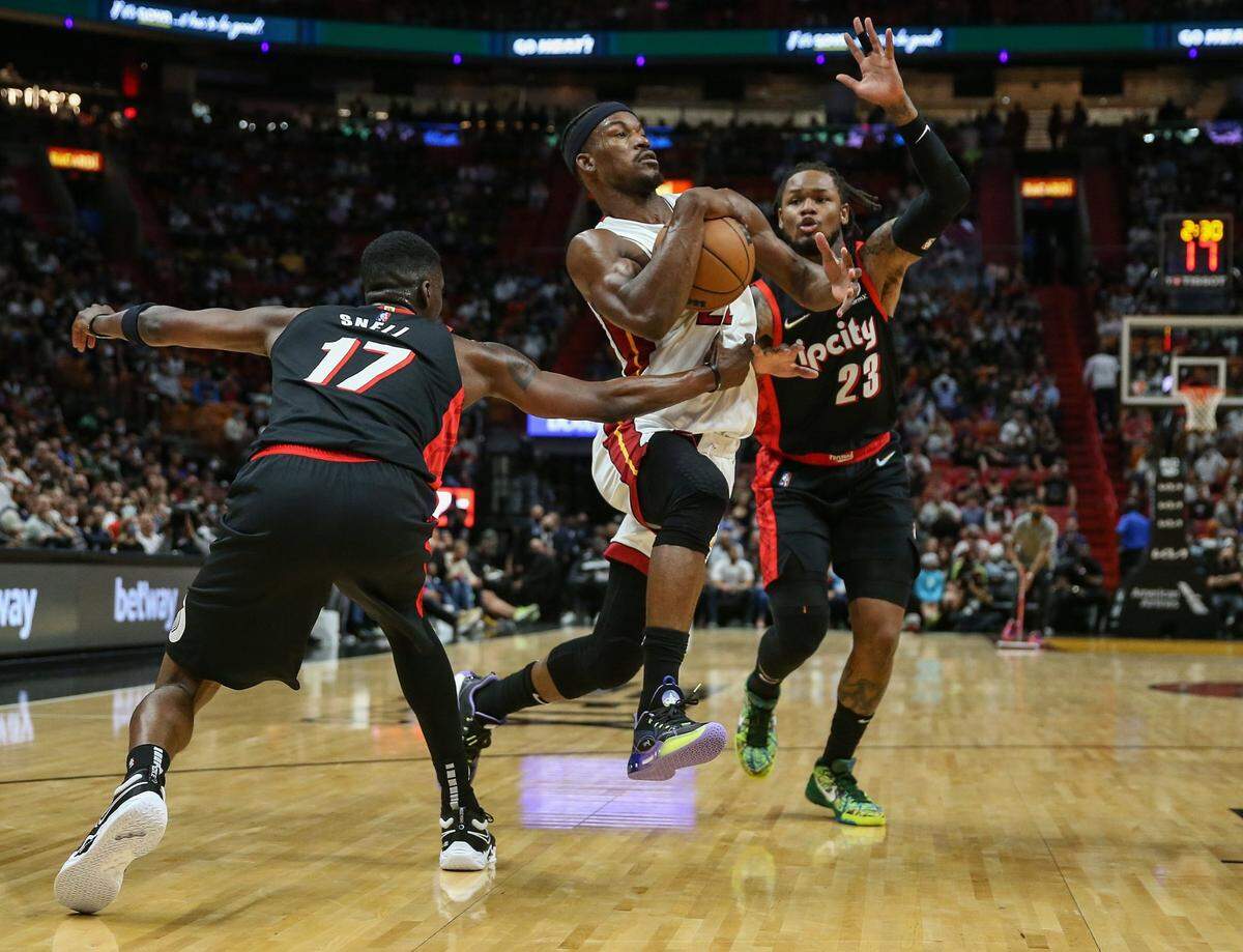 El jugador del Heat Jimmy Butler entra al aro ante la marca de Tony Snell (17) y Ben McLemore (23), de los Trail Blazers de Porltand, en el partido celebrado el 19 de enero de 2022 en el FTX Arena de Miami.