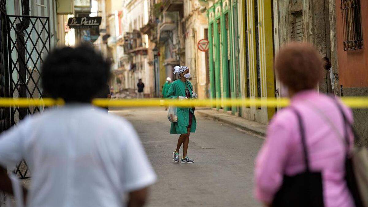El personal de apoyo de Covid-19 camina por una calle acordonada después de que se detectaran casos de coronavirus en La Habana, el 7 de abril de 2021.