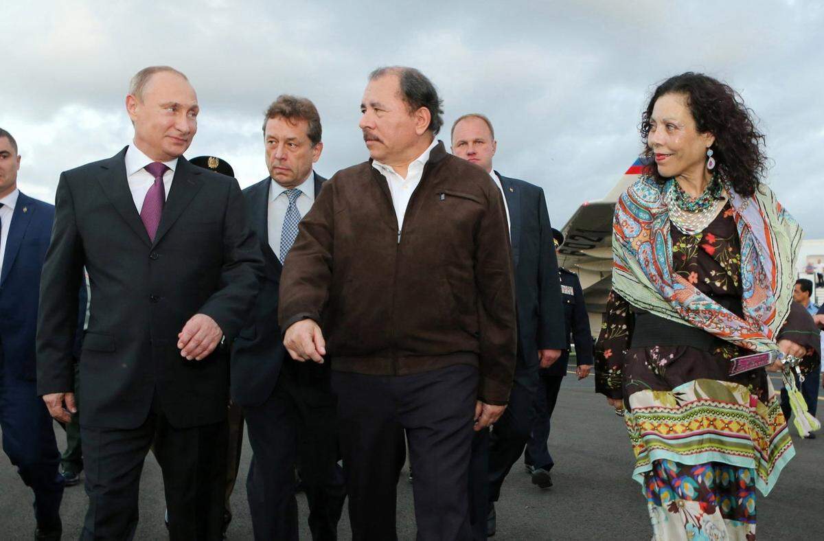 El gobernante de Nicaragua, Daniel Ortega, y la primera dama y vicepresidenta, Rosario Murillo, reciben al mandatario ruso Vladimir Putin, el 11 de julio de 2014, en el aeropuerto internacional de Managua, Nicaragua. (Cesar Pérez/AP)