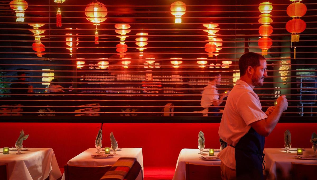 El chef Adrian Ochoa pasa junto a la larga pared de espejos del restaurante chino Double Luck.