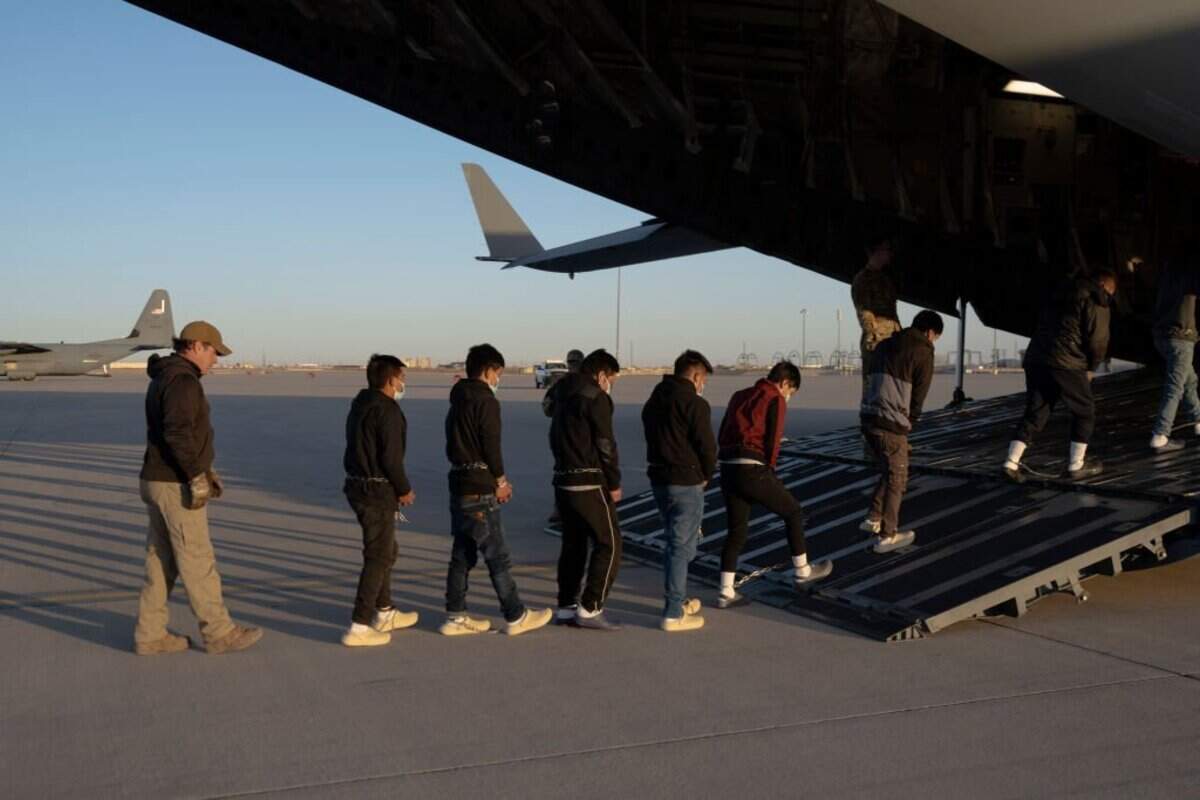 En esta imagen proporcionada por el Departamento de Defensa de EE.UU agentes de seguridad de la Oficina de Aduanas y Protección Fronteriza de EEUU guían a inmigrantes indocumentados a bordo de un C-17 Globemaster III asignado al 60.º Ala de Movilidad Aérea para un vuelo de deportación en Fort Bliss, Texas, el 23 de enero de 2025.
