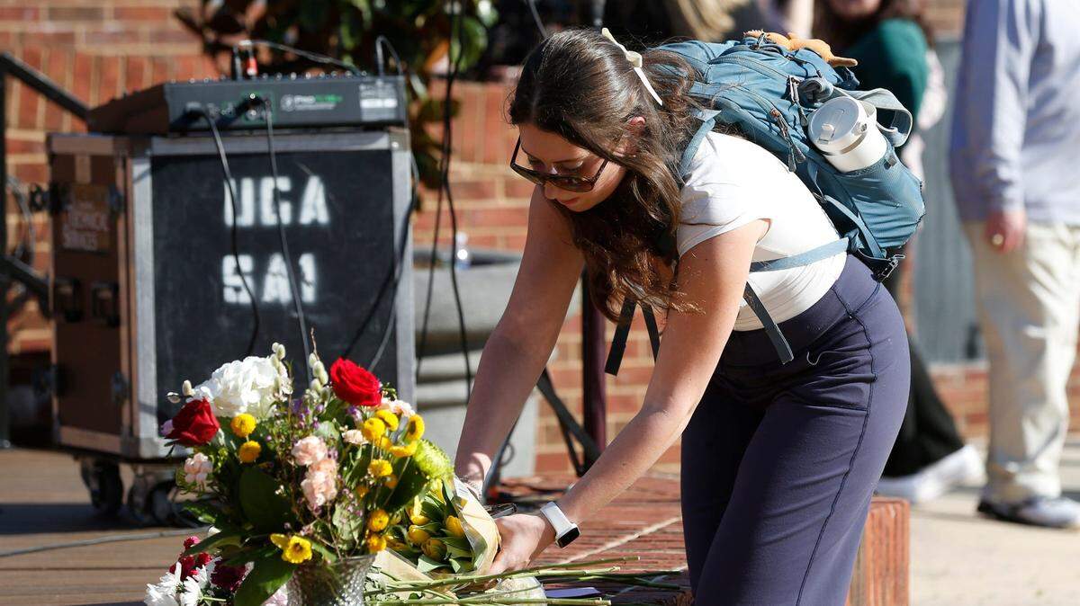 Una estudiante de la Universidad de Georgia deja flores después de una vigilia para Laken Riley, el 22 de febrero de 2024.