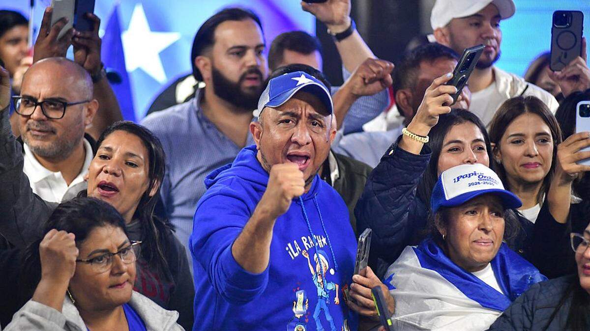 Simpatizantes del recién electo presidente de Honduras, Nasry Asfura, reaccionan en la sede del Partido Nacional, el 23 de diciembre de 2025 en Tegucigalpa. 
