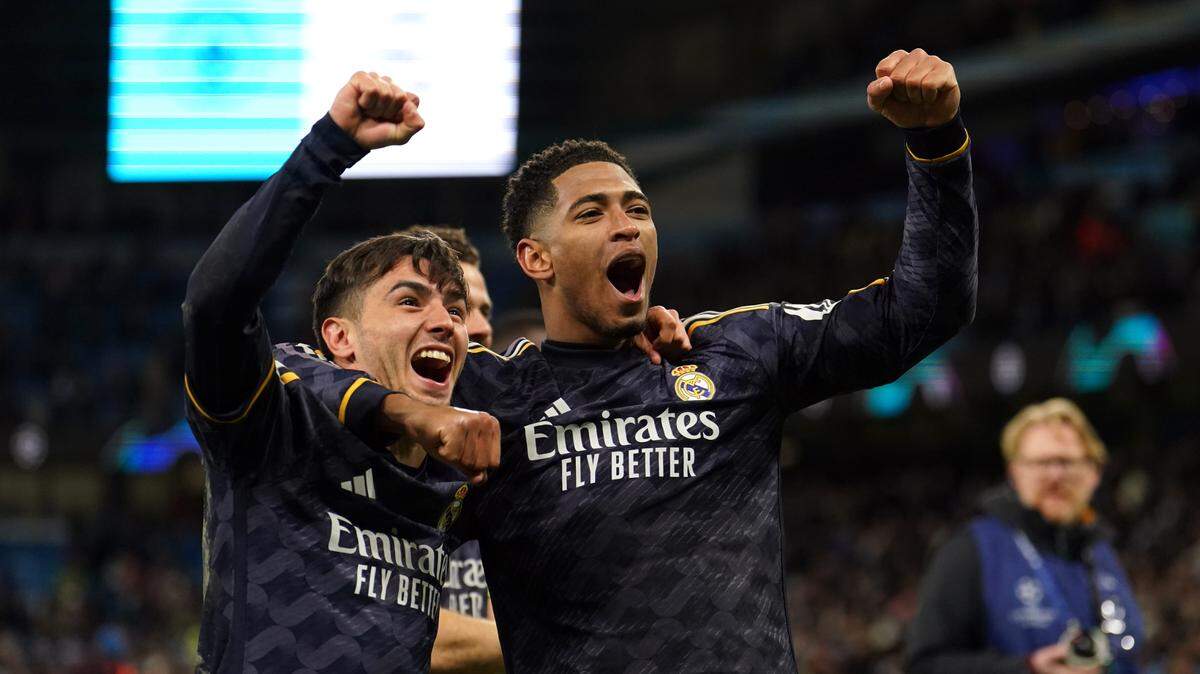 El jugador del Real Madrid Jude Bellingham (der.) celebra con sus compañeros de equipo el triunfo ante el Manchester City que los colocó en la semifinal de la Liga de Campeones, en el partido celebrado el 17 de abril de 2024 en Manchester, Inglaterra.