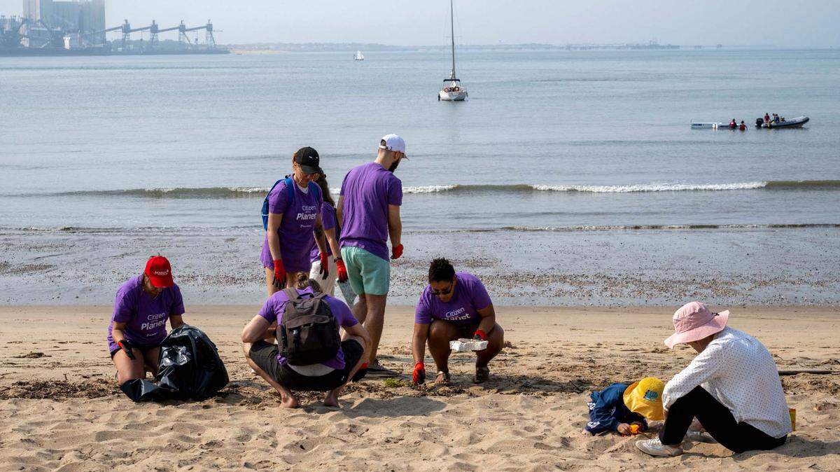 Varios voluntarios recogen basura de una playa en Lisboa, Portugal, el 21 de septiembre de 2024. Un informe reciente advierte del rápido calentamiento de los océanos.