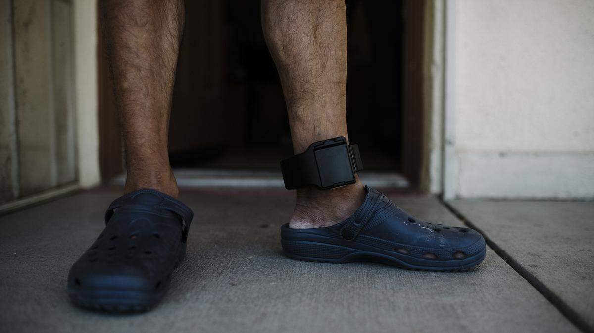 Un emigrante ubicado en Tucson, Arizona, lleva puesto un brazalete electrónico en el tobillo que permite a los agentes de inmigración localizarlo.