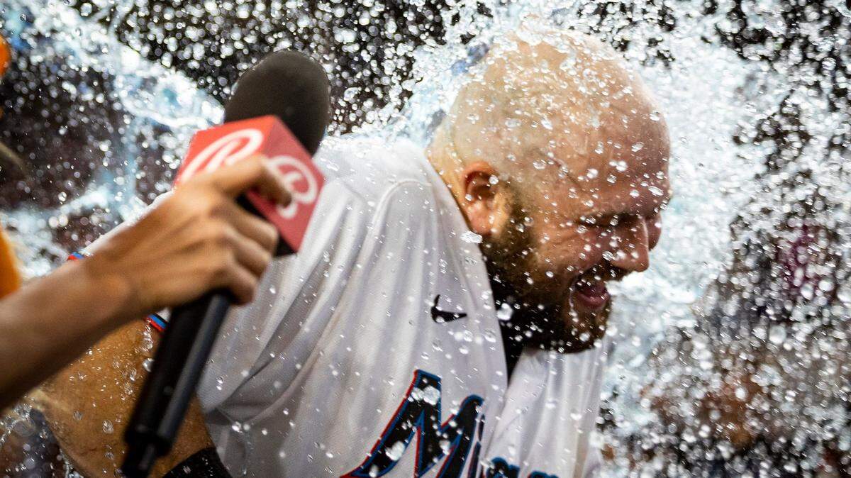 El tercera base Jake Burger es bañado con agua por sus compañeros de equipo tras pegar el hit que le dio el triunfo a los Marlins 8-7 ante los Yankees de Nueva York, en el partido celebrado el 13 de agosto de 2023 en Miami.