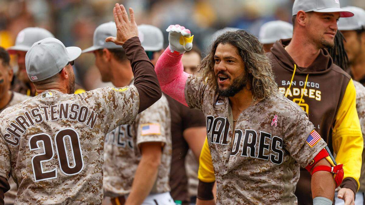 El colombiano Jorge Alfaro celebra con sus compañeros de equipo de los Padres tras pegar el jonrón que dejó al campo a los Marlins, el domingo 8 de mayo de 2022 en San Diego.