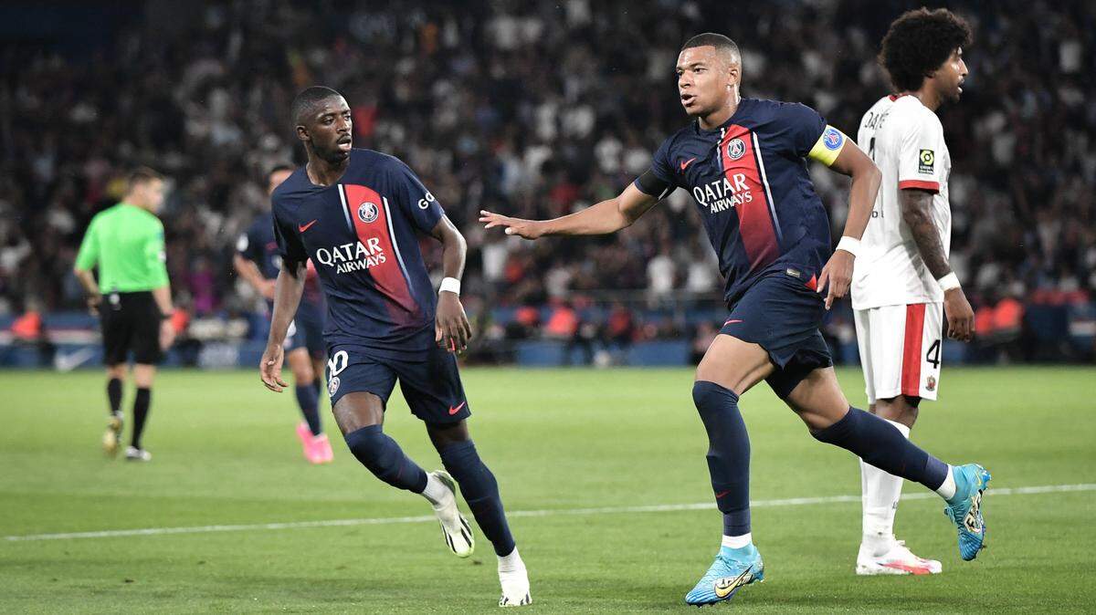 El delantero del Paris Saint-Germain Kylian Mbappé (der.) celebra con Ousmane Dembélé tras anotar un gol en un partido de la liga francesa ante Noza, el 15 de septiembre de 2023.
