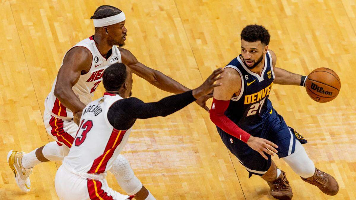Denver Nuggets point guard Jamal Murray (27) drives while defended by Miami Heat forward Jimmy Butler (22) and center Bam Adebayo (13) during the first half of Game 4 of the NBA Finals at the Kaseya Center on Friday, June 9, 2023, in downtown Miami, Fla.