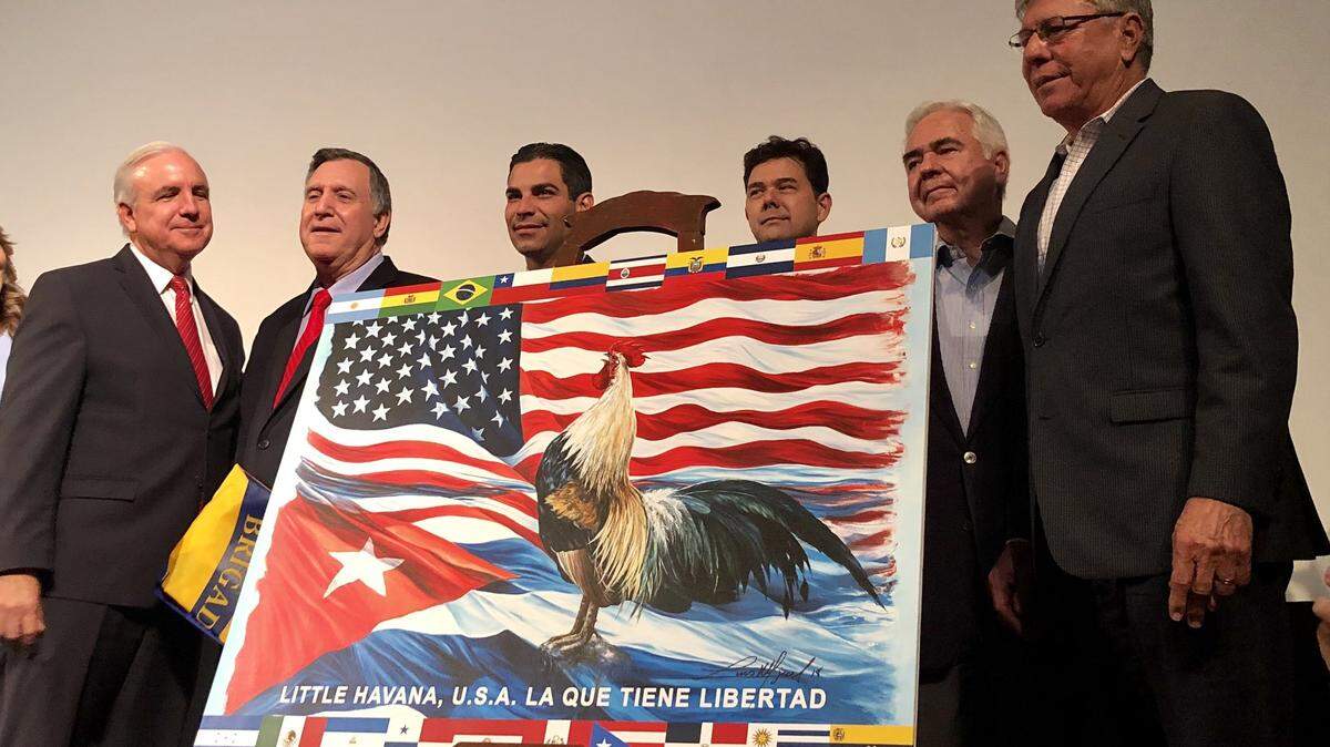 El alcalde de Miami, Carlos A. Giménez, presenta la nueva bandera de la Pequeña Habana.