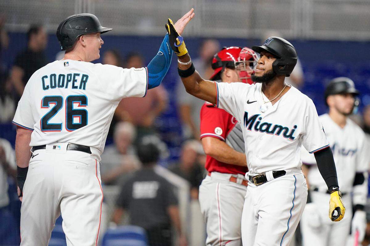 El jardinero de los Marlins Bryan De La Cruz (der.) recibe la felicitación de Garrett Cooper tras pegar un jonrón en el cuarto inning del partido ante los Filis de Filadelfia, celebrado el 15 de septiembre de 2022 en Miami.