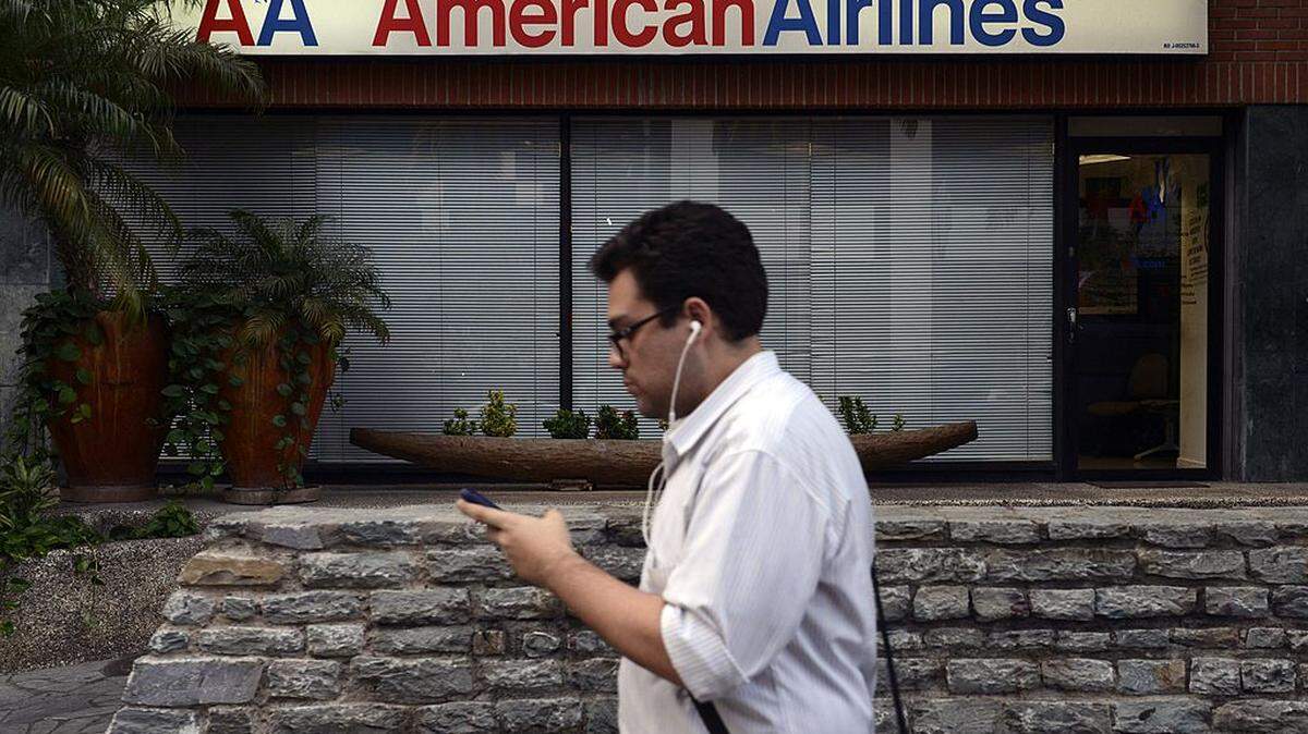 Un hombre camina junto a una oficina de venta de boletos de American Airlines en Caracas el 17 de junio de 2014.
