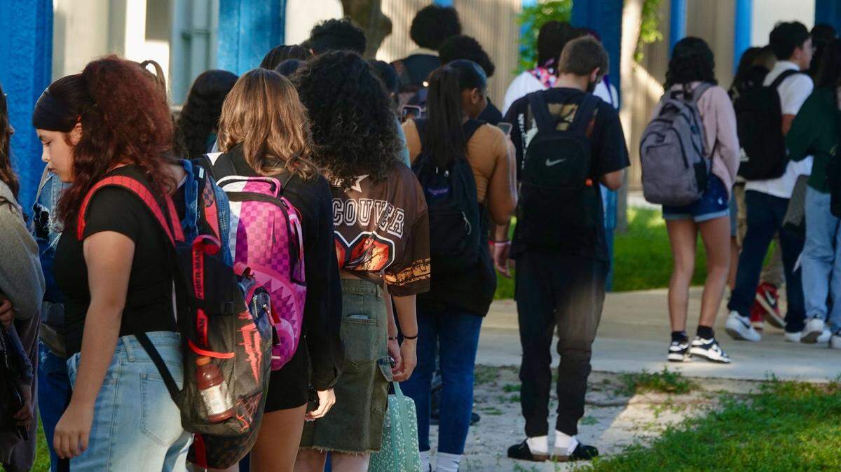 Students line up to pass through metal detectors on the first day of school in Broward county.