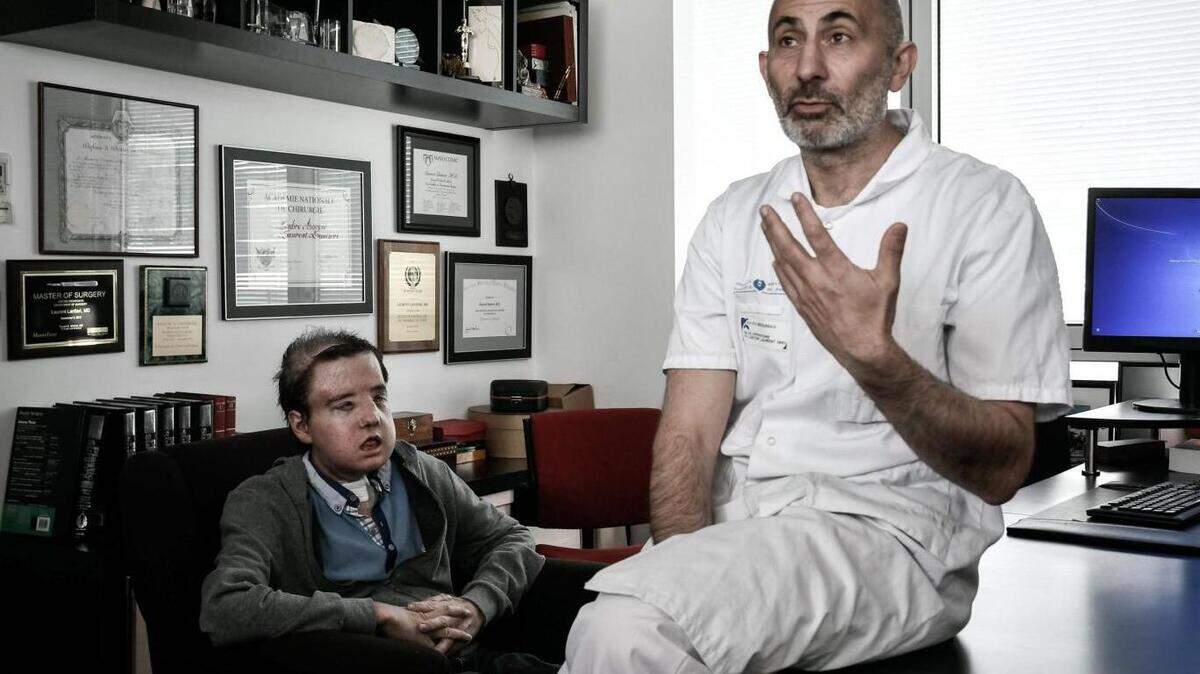 El profesor de medicina francés Laurent Lantieri, especialista en trasplante de manos y rostro, posa con su paciente Jerome Hamon