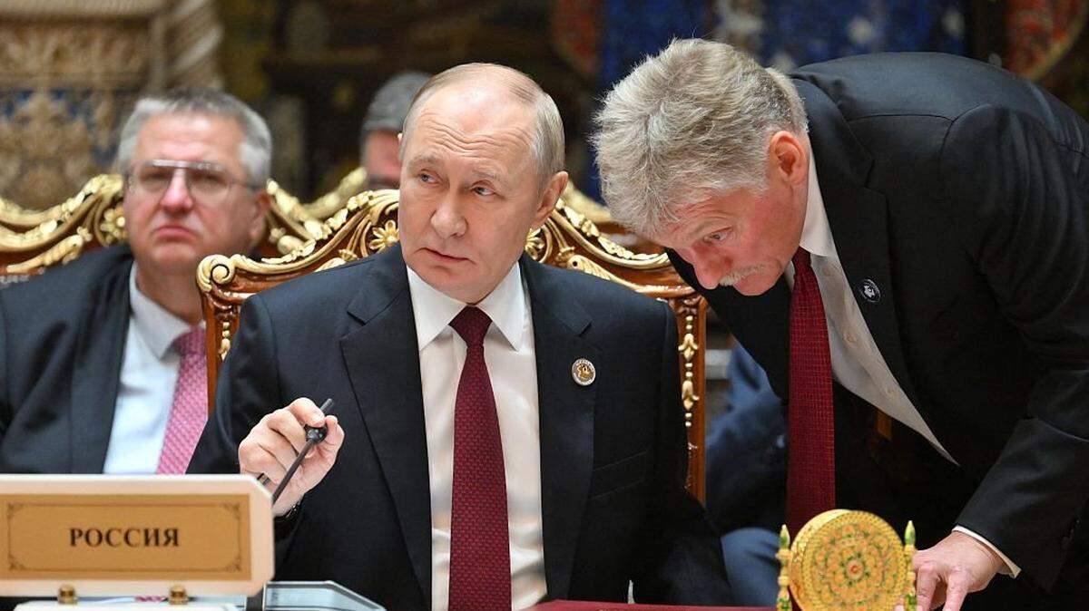 In this pool photograph distributed by the Russian state agency Sputnik, Russia's President Vladimir Putin talks to Kremlin spokesman Dmitry Peskov during an expanded meeting of the Commonwealth of Independent States (CIS) Heads of State Council at the Palace of Nation in Dushanbe on October 10, 2025. (Photo by Grigory SYSOYEV / POOL / AFP) (Photo by GRIGORY SYSOYEV/POOL/AFP via Getty Images)