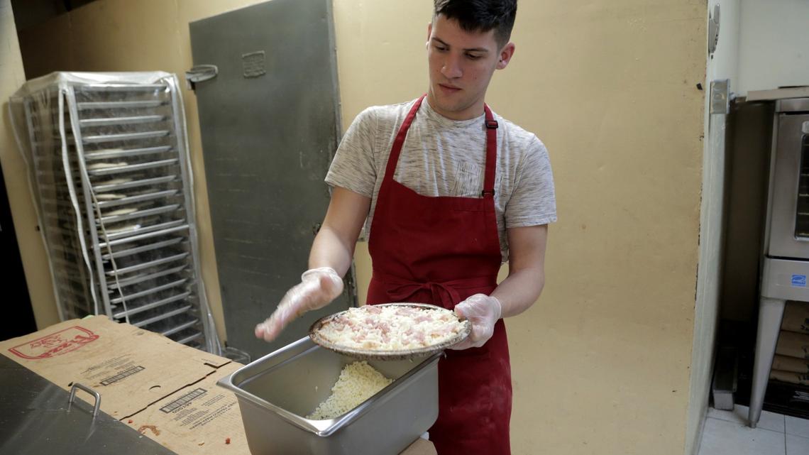 Gilberto Suarez Jr. pone los toques finales a la masa para las pizzas en el restaurante de la familia, Cono Pizza, 1200 SW 67 Ave., Miami.