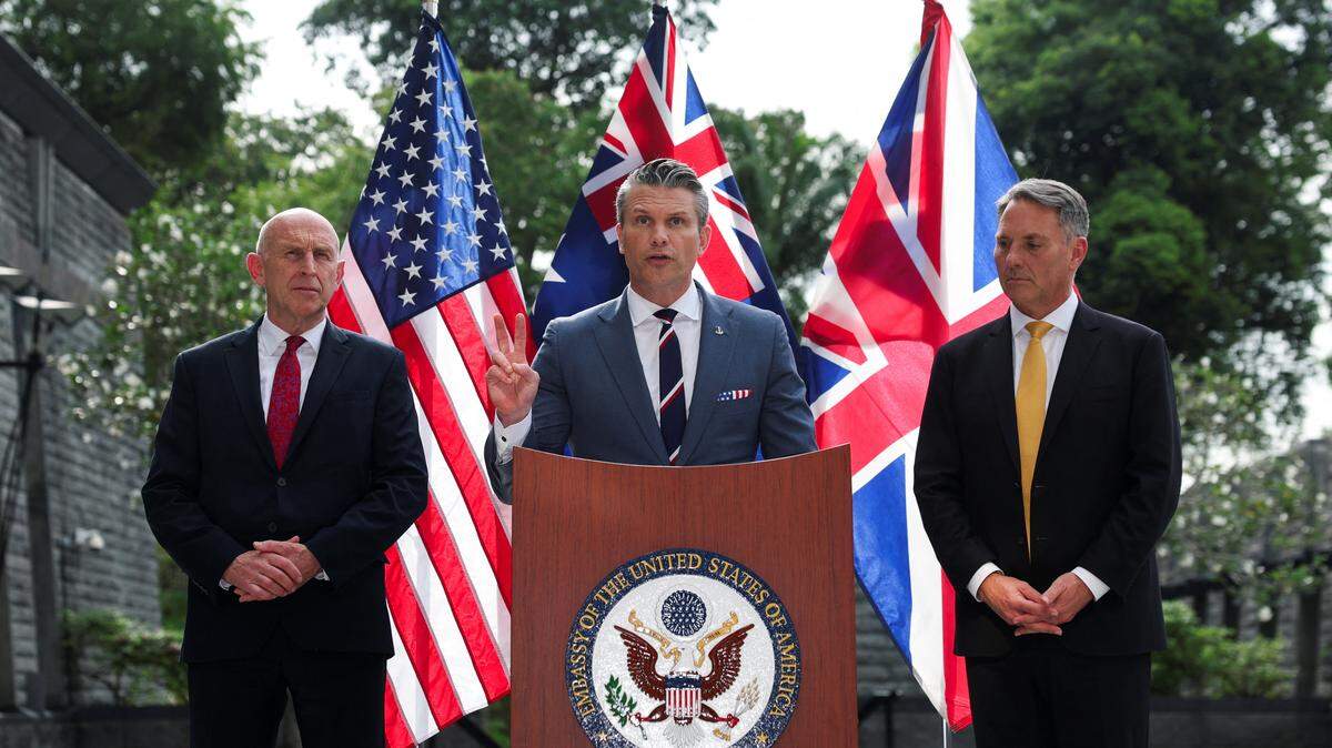 El ministro de Defensa australiano, Richard Marles, y el secretario de Defensa británico, John Healey, observan mientras el secretario de Defensa estadounidense, Pete Hegseth, habla durante una rueda de prensa conjunta de ministros de Defensa de Australia y Estados Unidos en la Embajada de Estados Unidos en Singapur, el 30 de mayo de 2026.