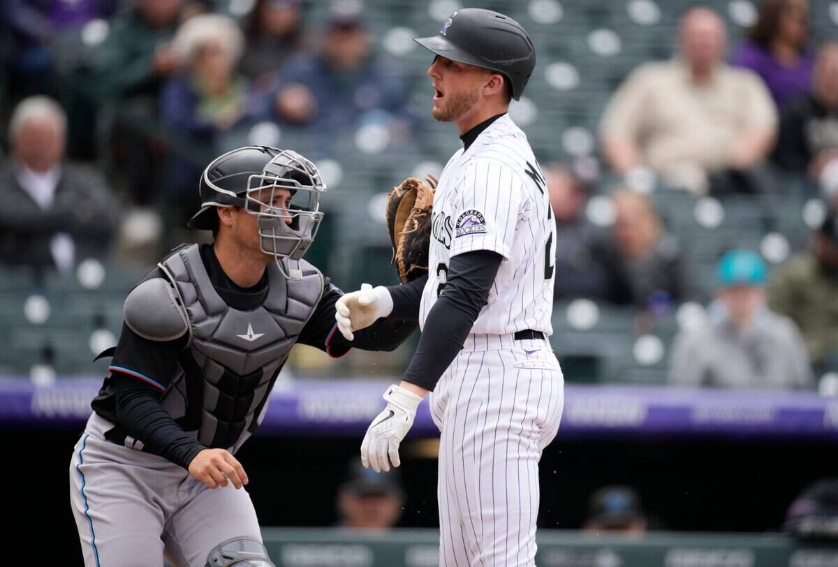 El receptor de los Marlins Nick Fortes toca a Ryan McMahon, de los Rockies, tras poncharse en el tercer inning del partido celebrado el 1ro de junio de 2022 en Colorado.