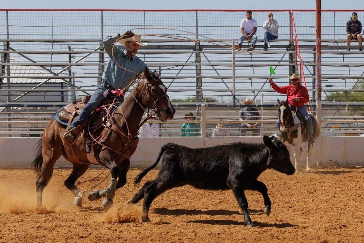 Raymond Norris galopa tras un ternero en la competición de lazo rápido (*breakaway roping*) durante el Texas Tradition Rodeo, en Denton, Texas, el 16 de abril de 2023. Los vaqueros compiten en eventos clásicos y temerarios del rodeo —tales como el eslalon entre postes, la carrera de barriles, el lazo de terneros y la monta de toros—.