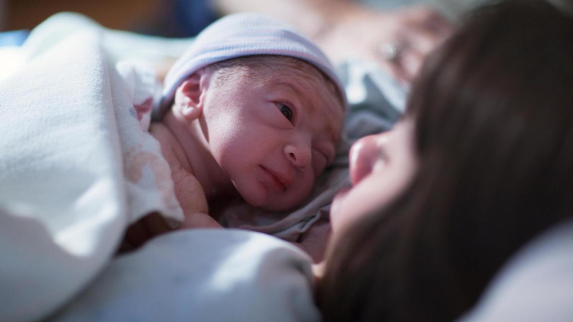 En esta imagen artística de archivo, un bebé descansa en el regazo de su madre en un hopital.