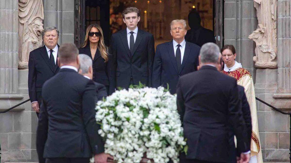 De izquierda a derecha, Barron Trump, Viktor Knavs, el ex presidente Donald Trump, y Melania Trump, mientras esperan que los sepultureros terminen de subir el ataúd de Amalia Knavs, la madre de Melania, a la carroza fúnebre, el jueves 18 de enero de 2024.