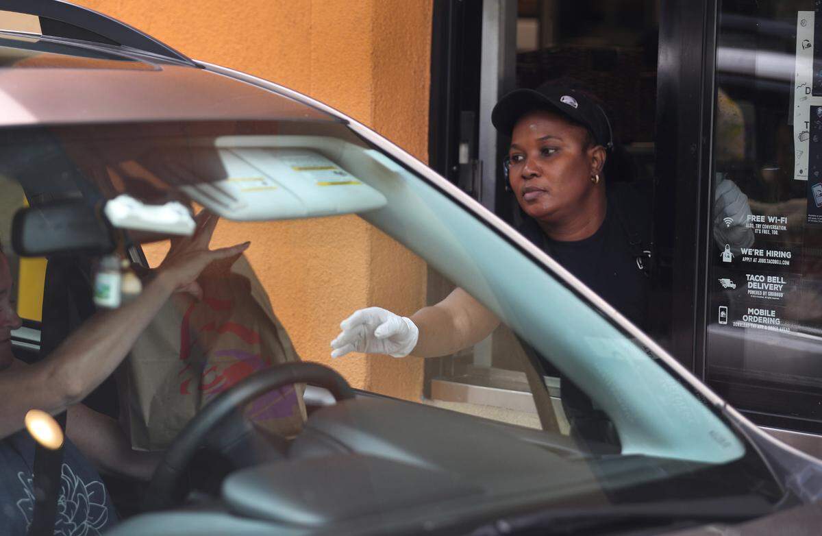 Una empleada de Taco Bell atiende a un cliente en la ventanilla de una sucursal en Hollwyood, Florida, en marzo.