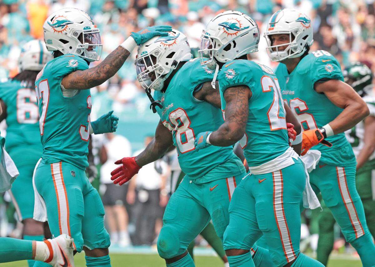 El running back de los Dolphins Duke Johnson (28) celebra con sus compañeros de equipo tras anotar un touchdown en el partido ante los Jets de New York, el 19 de diciembre de 2021 en Miami.