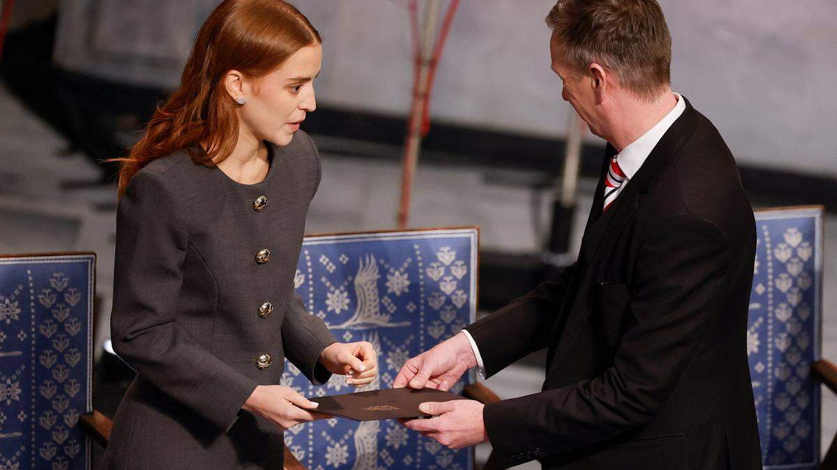 Ana Corina Sosa, daughter of Venezuelan opposition leader Maria Corina Machado is greeted by vice-chair of the Norwegian Nobel Committee Asle Toje as she represents her mother at the Nobel Peace Prize ceremony at Oslo City Hall on December 10, 2025 in Oslo, Norway. The 2025 Nobel Peace Prize was awarded to Machado for her efforts to bring democracy to Venezuela, challenging the iron-fisted rule of Venezuelan President Nicolas Maduro, who has been president since 2013. (Photo by Odd ANDERSEN / AFP via Getty Images)