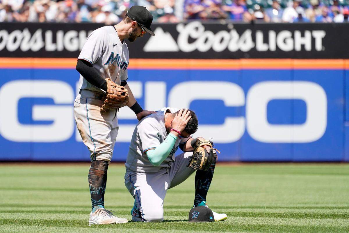 El pelotero de los Marlins de Miami Jon Berti (izq.) habla con Miguel Rojas luego de que ambos colisionaron al fildear un elevado de Francisco Lindor, de los Mets, en el partido celebrado el 10 de julio de 2022 en Nueva York.