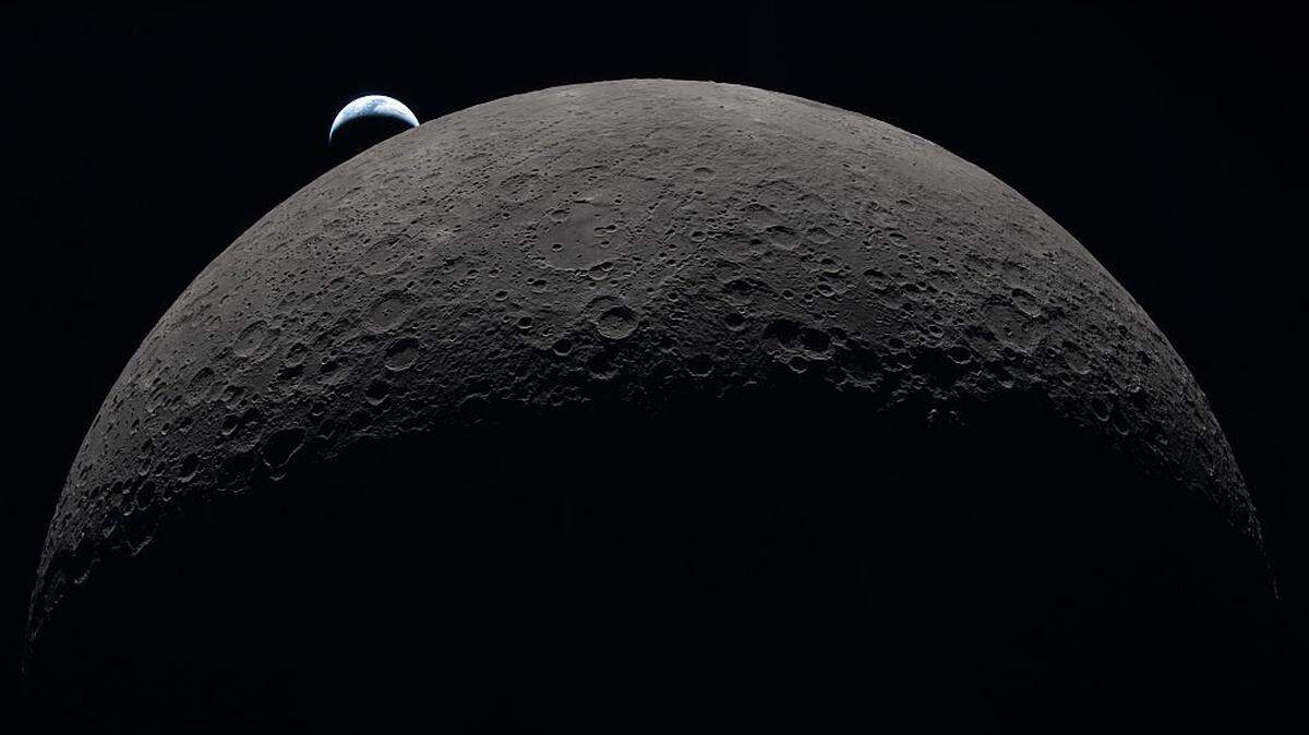IN SPACE - APRIL 06: (EDITOR'S NOTE: This Handout image was provided by a third-party organization and may not adhere to Getty Images' editorial policy.) In this handout image provided by NASA, Earth sets at 6:41 p.m. EDT, April 6, 2026, over the Moon's curved limb in this photo captured by the Artemis II crew during their journey around the far side of the Moon. Orientale basin is perched on the edge of the visible lunar surface. Hertzsprung Basin appears as two subtle concentric rings, which are interrupted by Vavilov, a younger crater superimposed over the older structure. The lines of indentations are secondary crater chains formed by ejecta from the massive impact that created Orientale. The dark portion of Earth is experiencing nighttime. On Earth's day side, swirling clouds are visible over the Australia and Oceania region. (Photo by NASA via Getty Images)