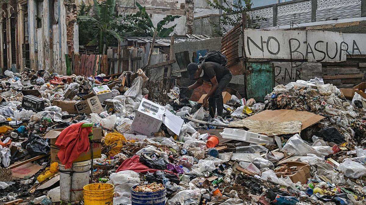 Foto de archivo de un hombre arrojando basura en una calle de La Habana el 23 de febrero de 2026, en medio de la crisis energética en Cuba, junto a un muro con el letrero que reza: “No basura”, en un contexto de acumulación de desechos y falta de combustible.