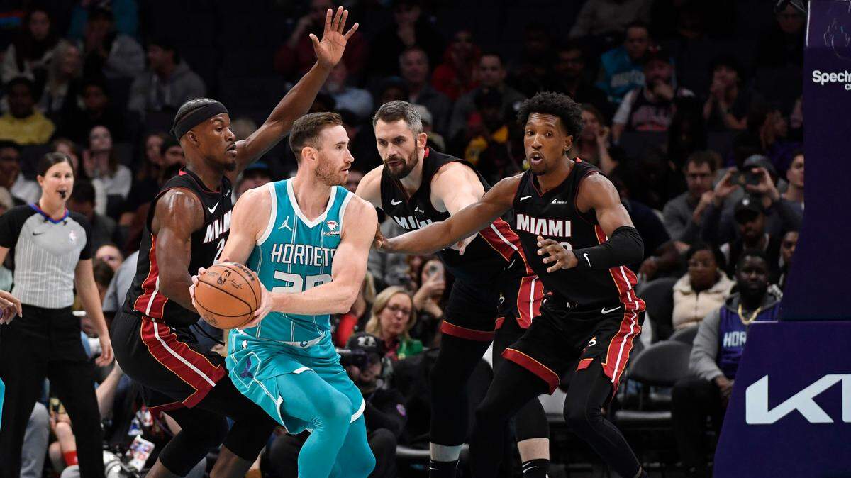 El delantero de Charlotte Hornets Gordon Hayward (20) espera pasar mientras es defendido por los jugadores del Miami Heat Jimmy Butler, Kevin Love y Josh Richardson en el Spectrum Center, este 11 de diciembre de 2023; Charlotte, Carolina del Norte.;