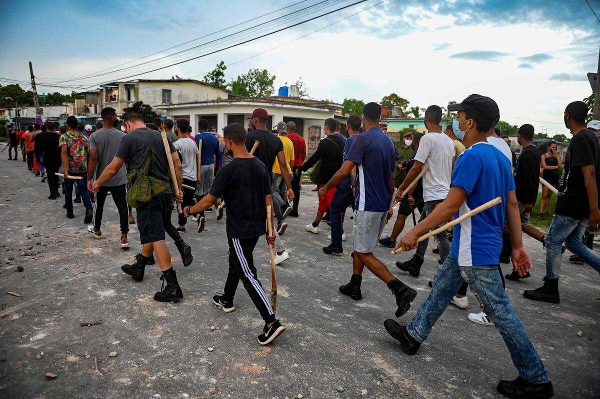 Un grupo de jóvenes armados con palos se preparan para reprimir a los manifestantes en Cuba, que siguen resistiendo la represión del gobierno de Díaz Canel, que ha militarizado la isla en una operación de control de las protestas. La foto es del 12 de julio en Arroyo Naranjo.