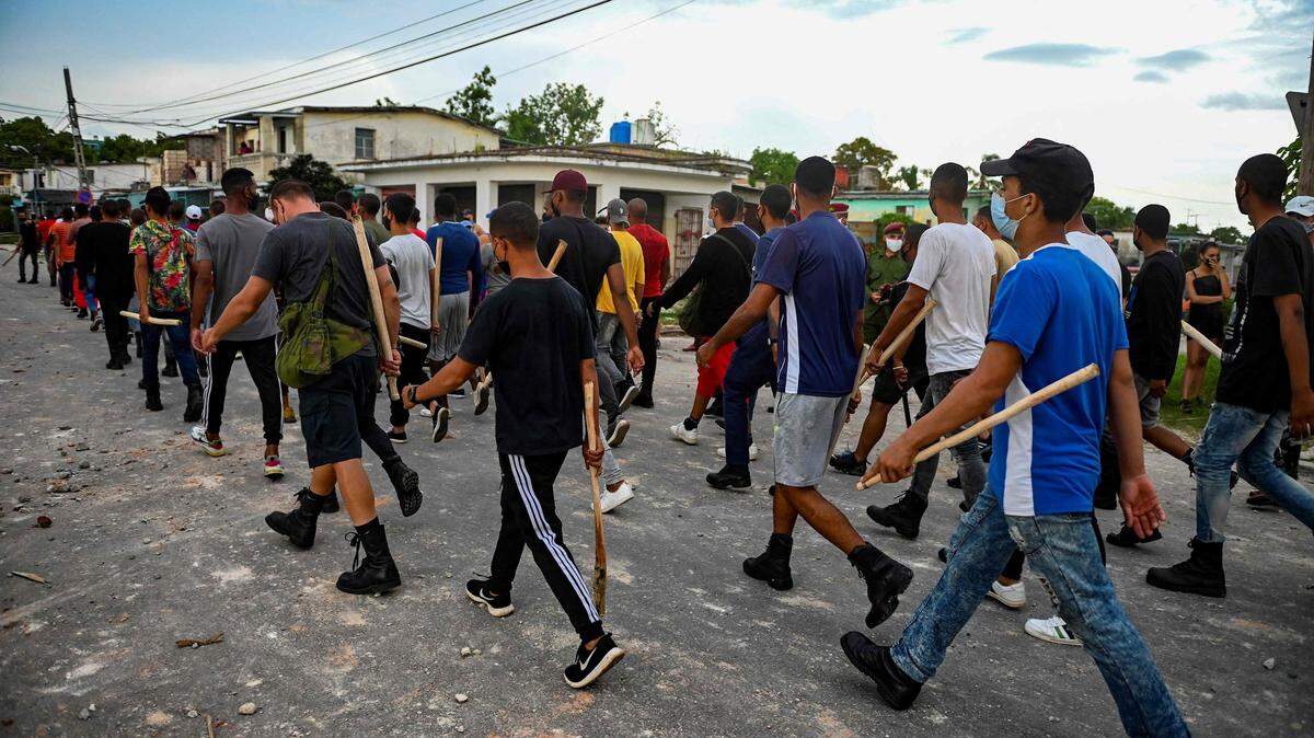 Un grupo de jóvenes armados con palos se preparan para reprimir a los manifestantes en Cuba, que siguen resistiendo la represión del gobierno de Díaz Canel, que ha militarizado la isla en una operación de control de las protestas. La foto es del 12 de julio en Arroyo Naranjo.