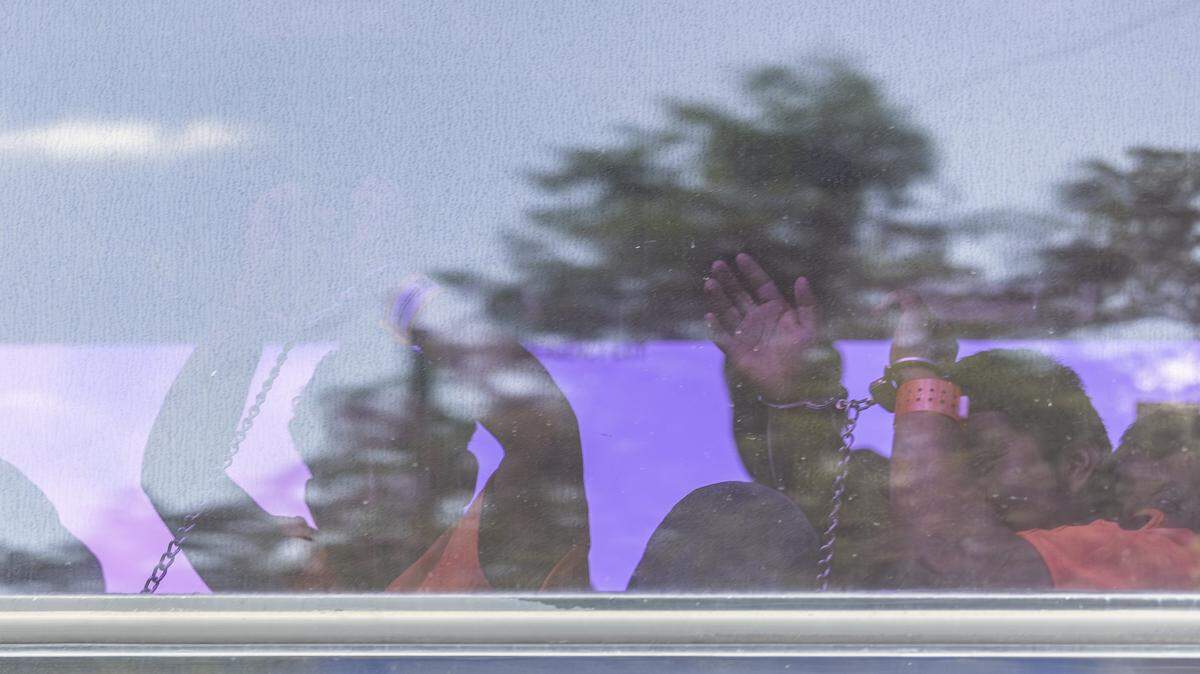 Inmigrantes esposados se marchan en autobús desde Alligator Alcatraz en agosto de 2025.