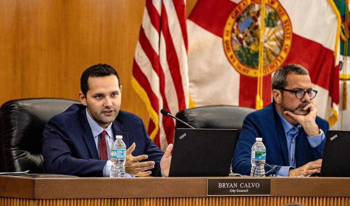 El concejal de la ciudad de Hialeah, Bryan Calvo (izquierda) y Carl Zogby, durante una tensa reunión del concejo el martes 25 de abril de 2023.