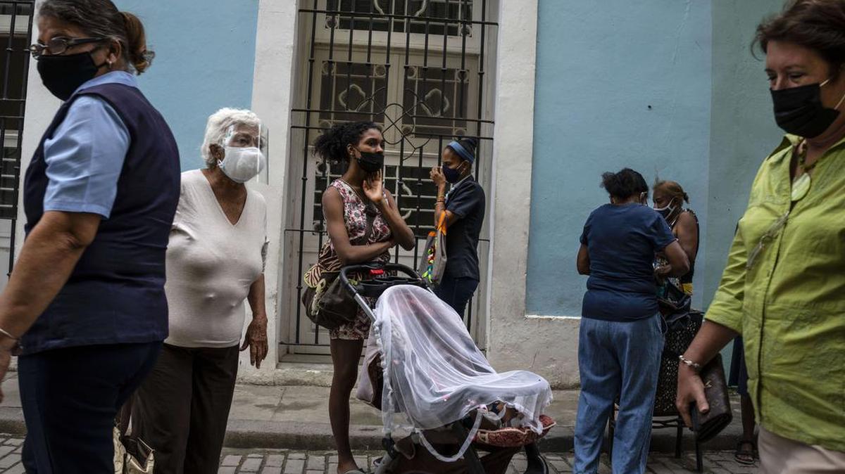 Las personas usan máscaras para frenar la propagación del COVID-19 mientras esperan su turno para comprar en una tienda estatal en La Habana, Cuba, el miércoles 16 de febrero de 2022. (AP Foto/Ramón Espinosa)