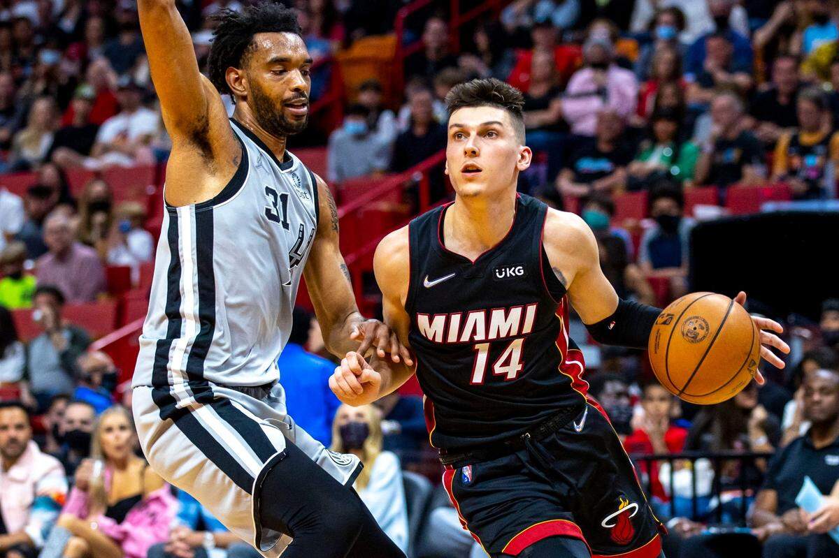 El jugador del Heat Tyler Herro (der.) trata de entrar al aro ante la marca de Keita Bates-Diop, de los Spurs de San Antonio, en el partido efectuado el 26 de febrero de 2022 en Miami.