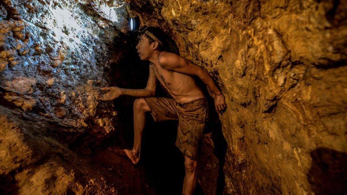 TOPSHOT - Ender Moreno looks for gold at La Culebra gold mine in El Callao, Bolivar state, southeastern Venezuela on March 1, 2017. - Although life in the mines of eastern Venezuela is hard and dangerous, tens of thousands from all over the country head for the mines daily in overcrowded trucks, pushed by the rise in gold prices and by the severe economic crisis affecting the country, aggravated recently by the drop in oil prices. (Photo by JUAN BARRETO / AFP) (Photo by JUAN BARRETO/AFP via Getty Images)