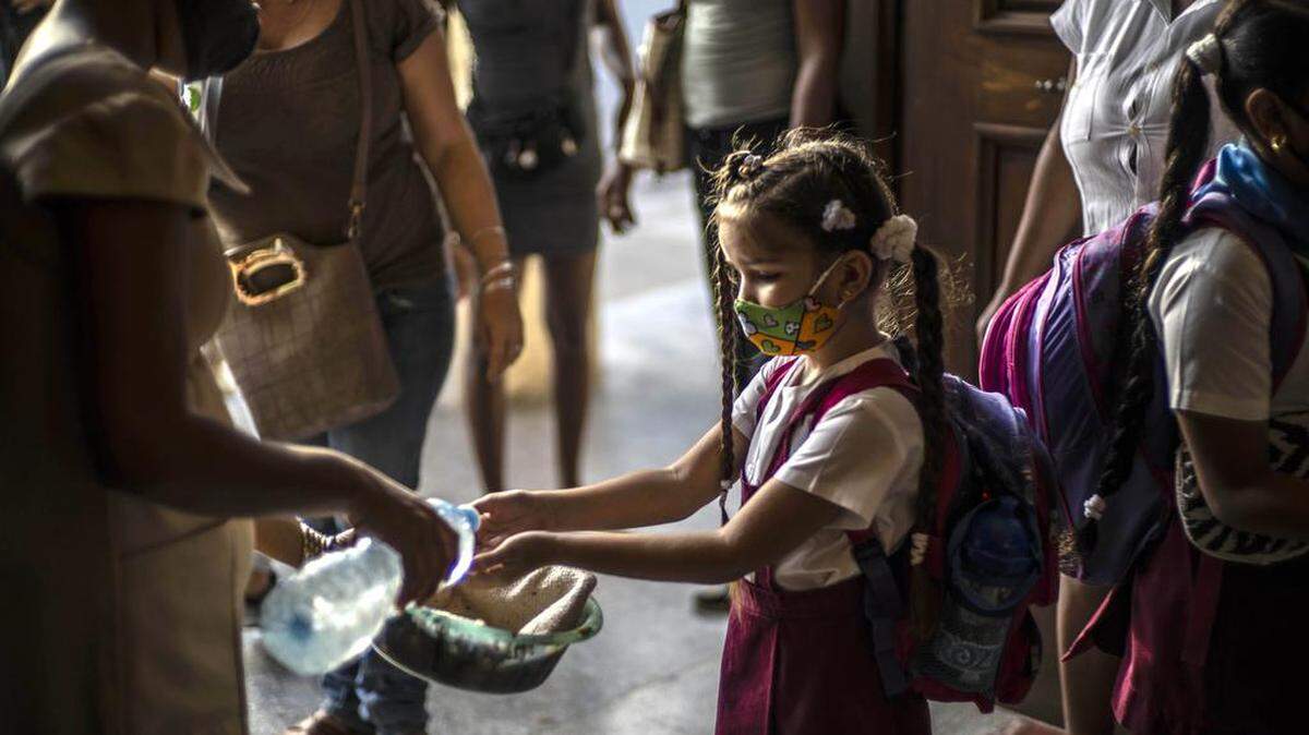 Foto de archivo: Con una máscara como medida de precaución en medio de la propagación del nuevo coronavirus, una estudiante se lava las manos al llegar a la escuela en La Habana, Cuba, el lunes 2 de noviembre de 2020.