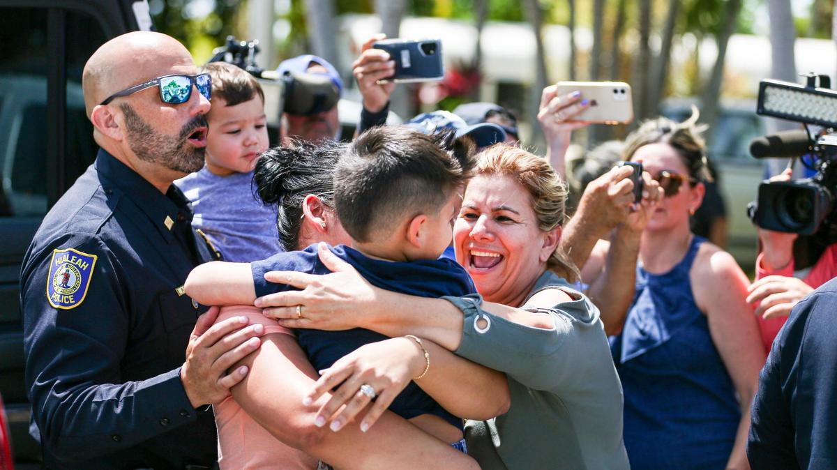 Los familiares se reúnen con sus seres queridos después de que la policía de Hialeah pudiera evacuar a siete niños de una guardería cerca de una casa donde un hombre con un rifle de asalto se atrincheró en 30 East 53rd Terrace en Hialeah, Florida, el jueves 28 de julio de 2022.