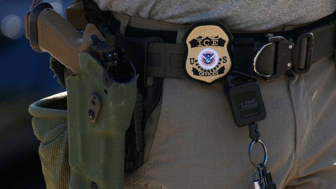 Se observan la placa y el arma de un agente del Servicio de Inmigración y Control de Aduanas (ICE) mientras ICE realiza un control vehicular en Georgia Ave. el 30 de agosto de 2025 en Washington, DC.
