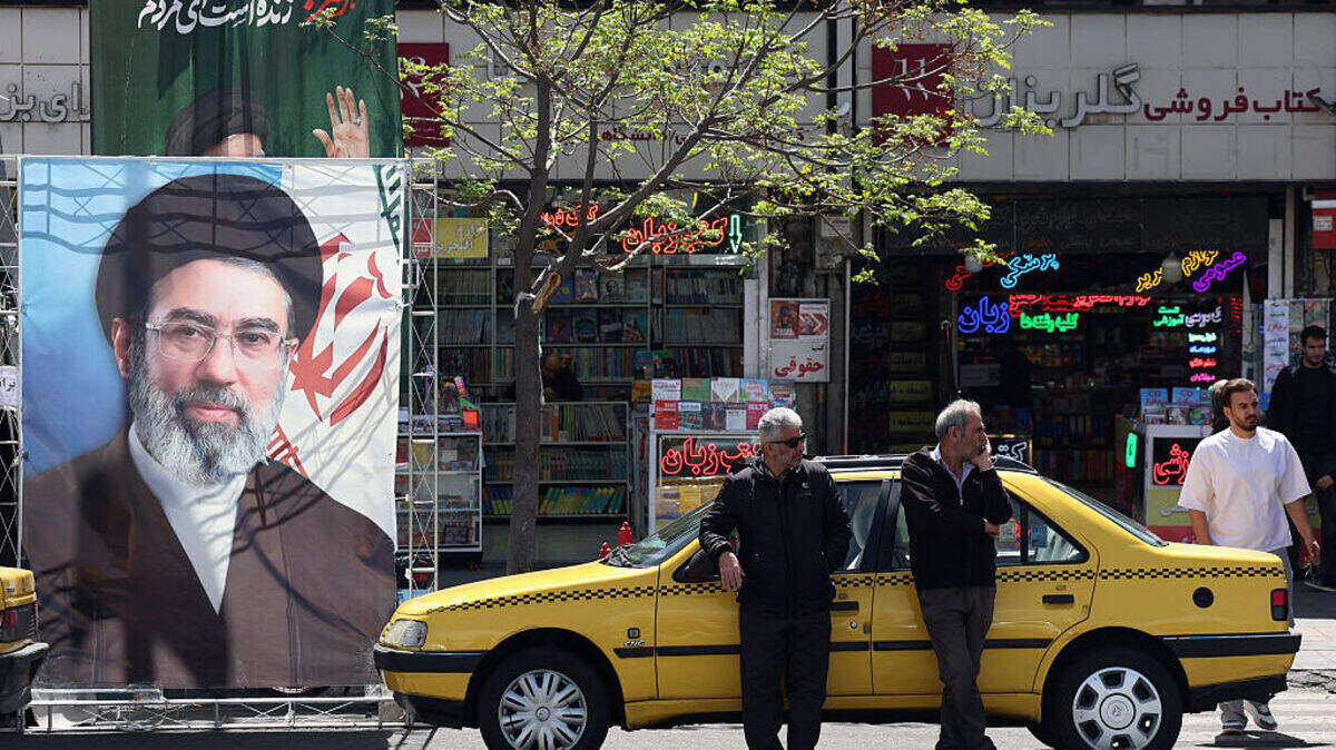 Un taxi se detiene junto a una pancarta que muestra al nuevo líder supremo de Irán, el ayatolá Mojtaba Khamenei, en una calle de Teherán, el domingo 5 de abril de 2026.