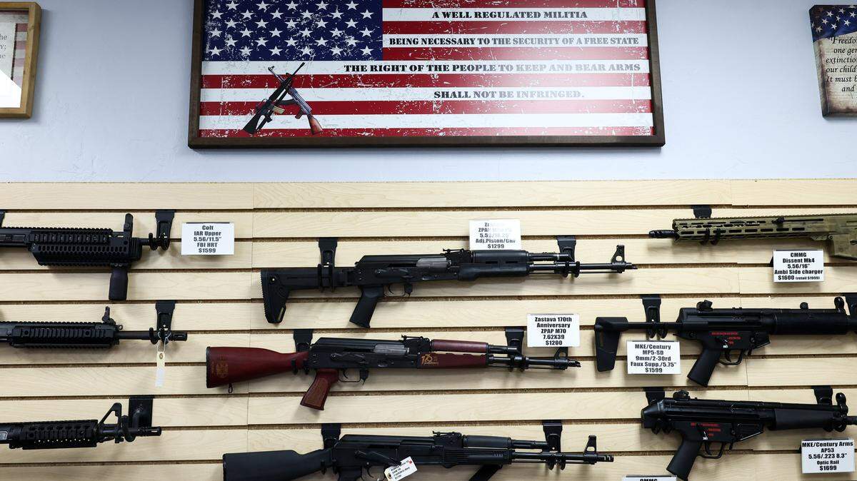 TOPSHOT - The second amendment (the right of the people to keep and bear arms) is spelled on a US flag above a display of firearms for sale in a gun store in Rio Rico, Santa Cruz County, Arizona on September 17, 2025. Arizona allows individuals legally eligible to own guns to carry them without a permit, background checks apply to dealer sales but not most private transactions. (Photo by CHARLY TRIBALLEAU / AFP) (Photo by CHARLY TRIBALLEAU/AFP via Getty Images)